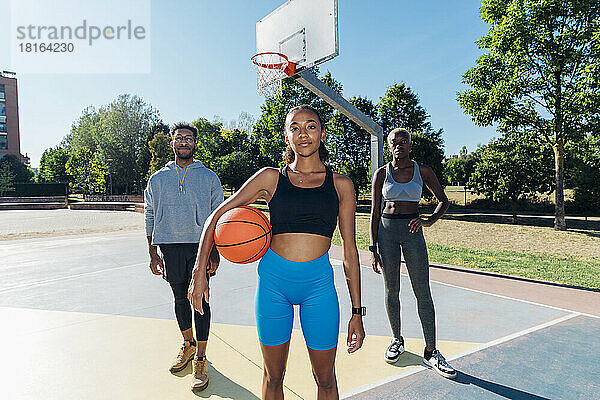 Selbstbewusste Basketballspieler auf dem Sportplatz an einem sonnigen Tag
