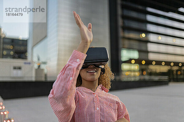 Lächelnde Frau gestikuliert und nutzt den Virtual-Reality-Simulator