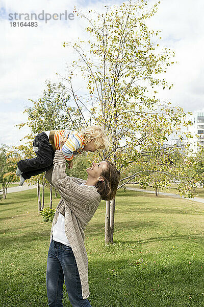Glückliche Mutter spielt mit Sohn im Park