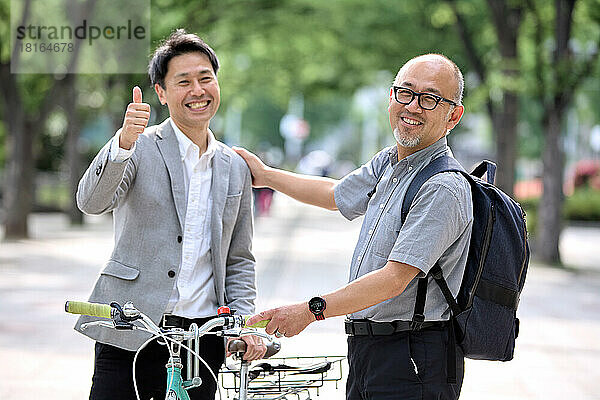 Lächelnde japanische Männer mit Fahrrad