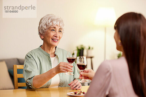 Japanische ältere und junge Frauen genießen Wein zu Hause