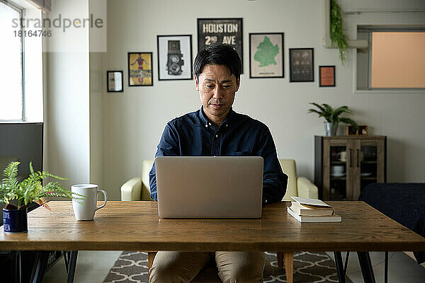 Japaner arbeitet von zu Hause aus am Laptop