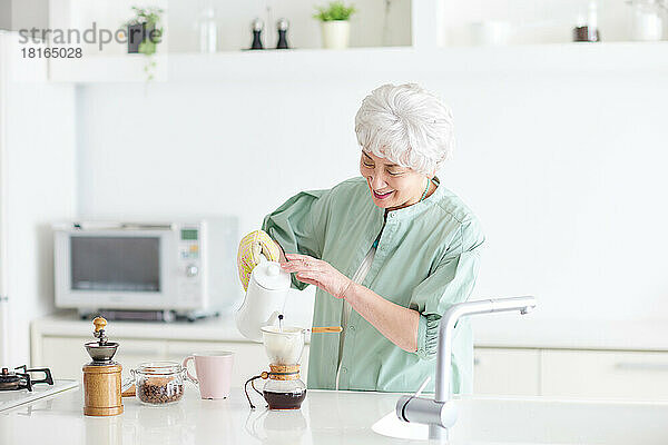 Japanische Seniorin brüht Kaffee
