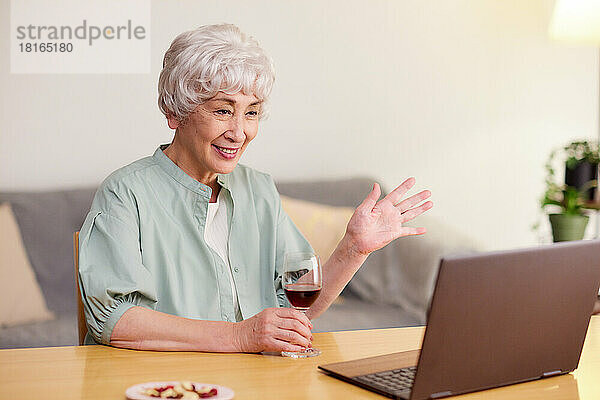 Japanische Seniorin bei einer Online-Trinkparty