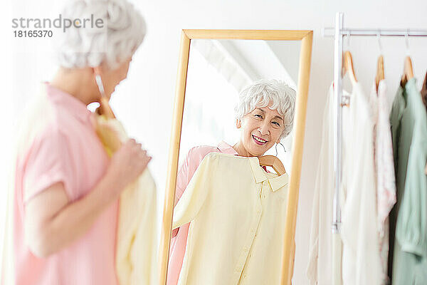 Japanische Seniorin wählt Kleidung aus