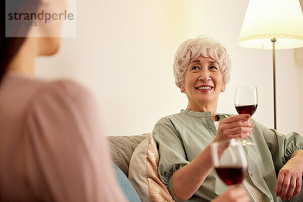 Japanische ältere und junge Frauen genießen Wein zu Hause