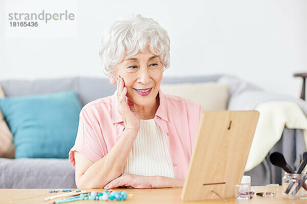 Japanische Seniorin beim Blick in den Spiegel