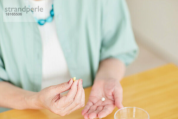 Japanische Seniorin nimmt Pillen