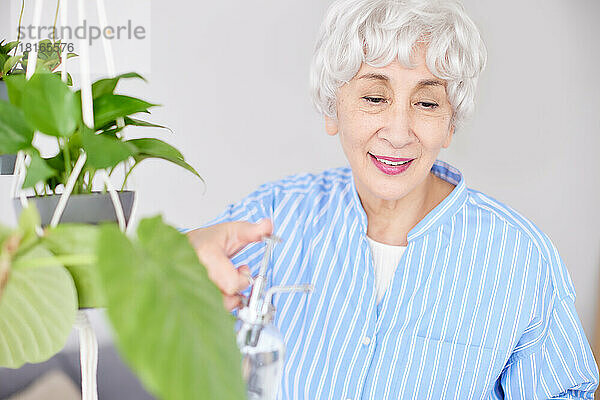 Japanische Seniorin beim Gießen von Pflanzen