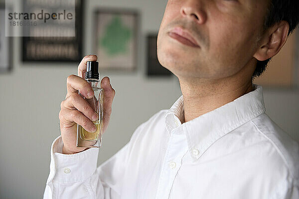 Japanischer Mann trägt Parfüm