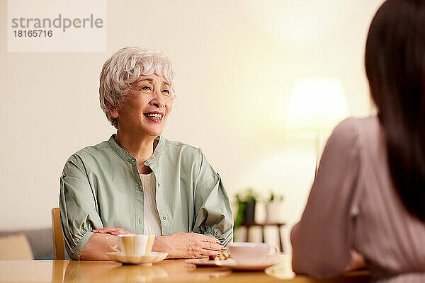 Japanische Seniorin und junge Frau genießen die Teestunde