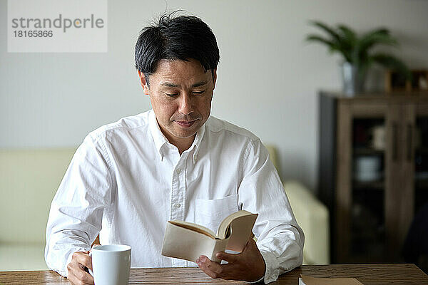 Japanischer Mann liest ein Buch