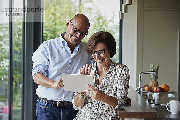 Glückliche Frau und Mann unterhalten sich per Videoanruf über Tablet-PC