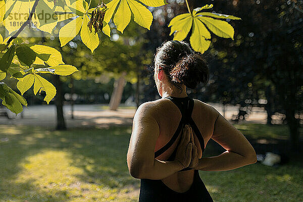 Fitnesstrainer macht Dehnübungen im Park