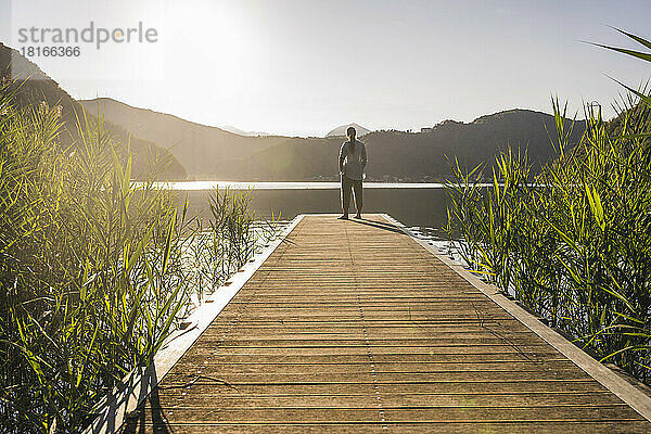 Woman standing on jetty over lake at vacation