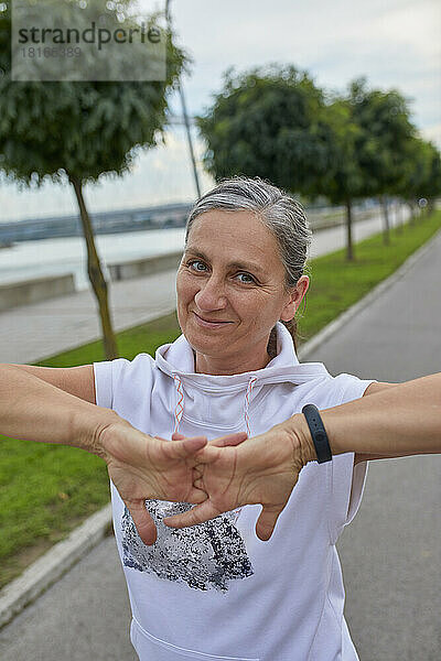 Lächelnde reife Frau streckt die Finger aus