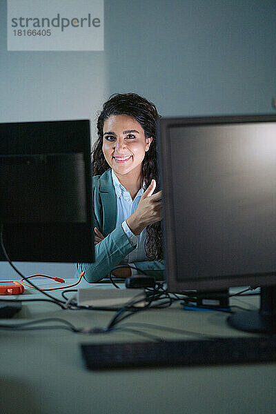Lächelnde Geschäftsfrau  gesehen durch Computer im Büro