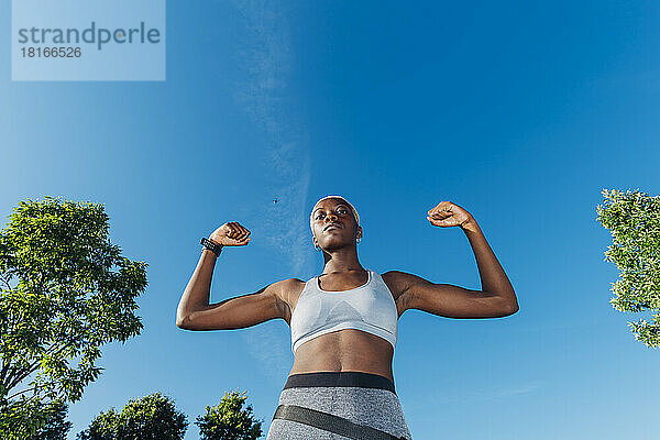 Selbstbewusste Sportlerin lässt an einem sonnigen Tag Muskeln spielen