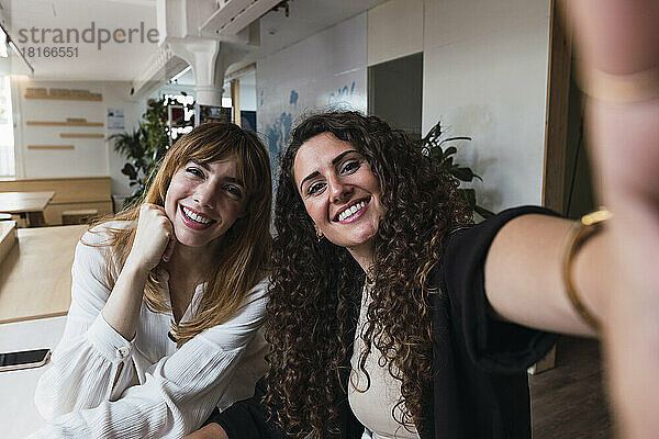 Zwei glückliche Geschäftsfrauen machen ein Selfie im Büro