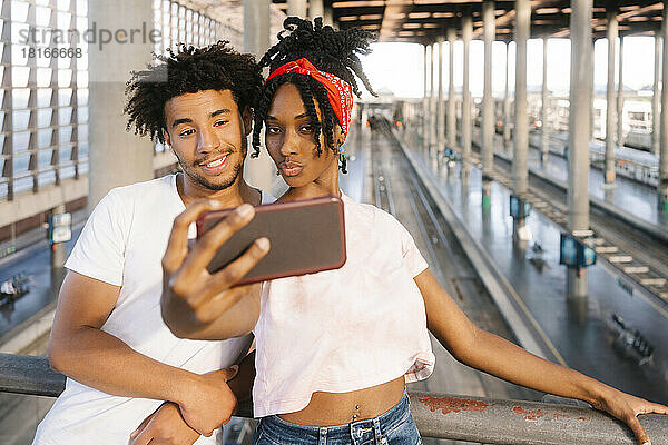 Gemischtrassige Freunde machen am Bahnhof ein Selfie mit dem Handy