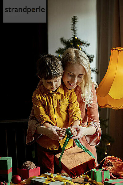 Mutter bringt ihrem Sohn bei  zu Hause Geschenke zu verpacken