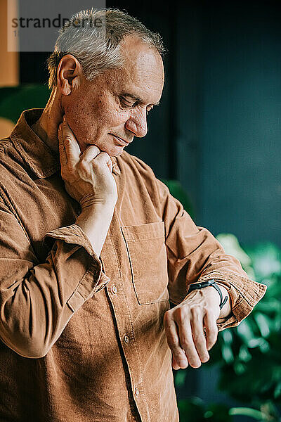 Älterer Mann überprüft Puls auf Armbanduhr