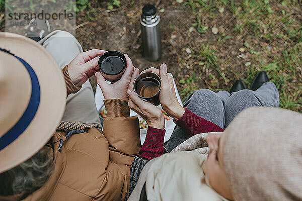 Paar sitzt bei einer Tasse Tee im Wald