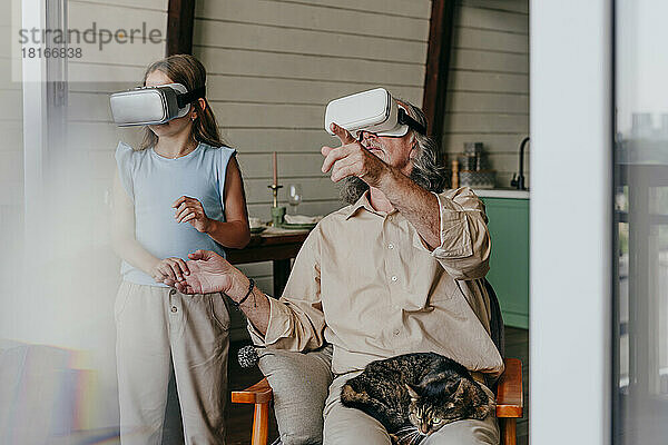 Enkelin und Großvater tragen zu Hause eine VR-Brille