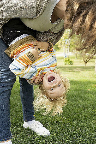 Fröhlicher Junge genießt und spielt mit seiner Mutter im Park