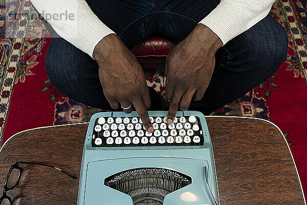 Hände eines Geschäftsmannes  der auf einer Vintage-Schreibmaschine tippt