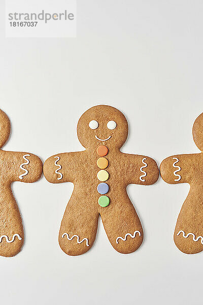 Freshly decorated gingerbread men lying on white background