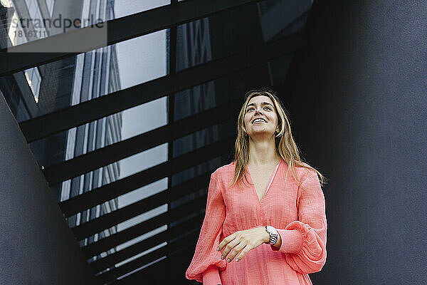 Lächelnde Frau vor modernem Gebäude