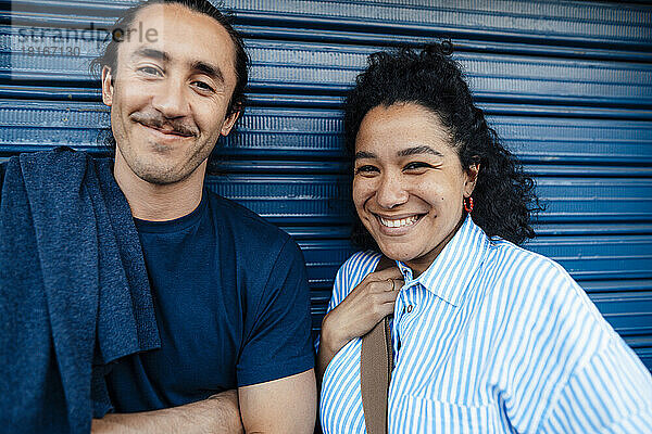 Lächelndes Paar vor blauem Verschluss