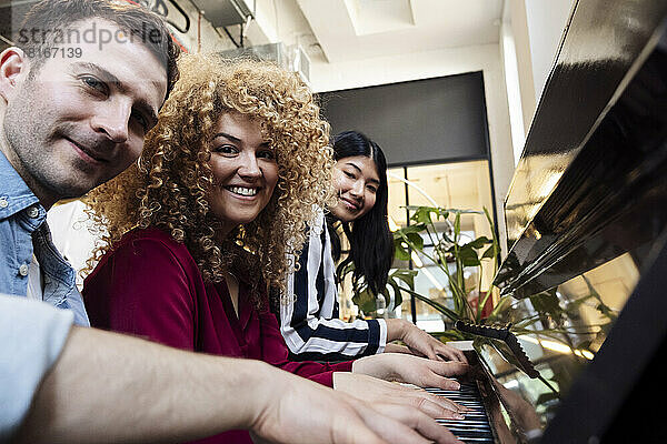 Glückliche Geschäftskollegen  die im Büro Musik spielen