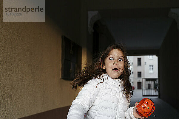 Verängstigtes Mädchen mit Kürbiskorb zu Halloween