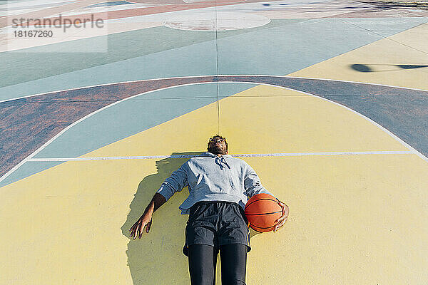 Tired basketball player lying on court