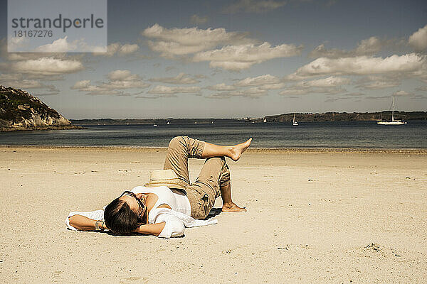 Reife Frau entspannt sich an einem sonnigen Tag am Strand