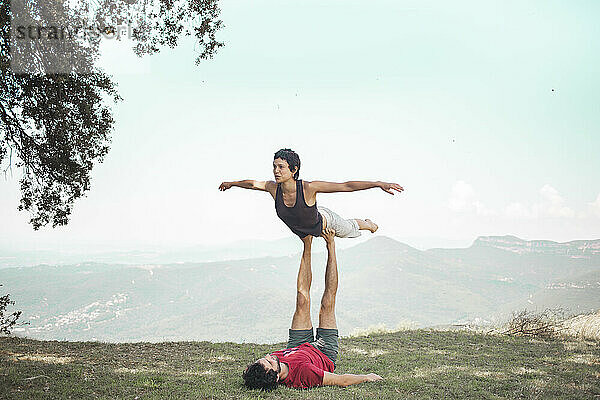Couple doing acroyoga in front of sky