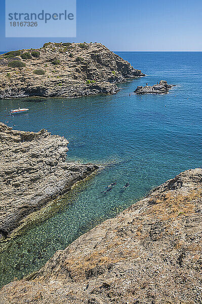Touristen schwimmen an sonnigen Tagen im Meer inmitten von Felsen