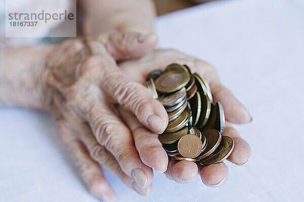 Faltige Hände einer älteren Frau  die Münzen hält