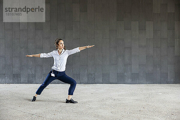 Frau praktiziert Yoga vor der Wand