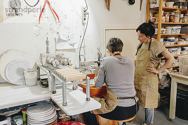 Unternehmer mit Kollegen  der in der Keramikwerkstatt arbeitet