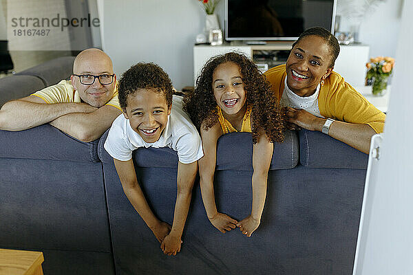Glückliche Kinder mit Eltern auf dem Sofa zu Hause