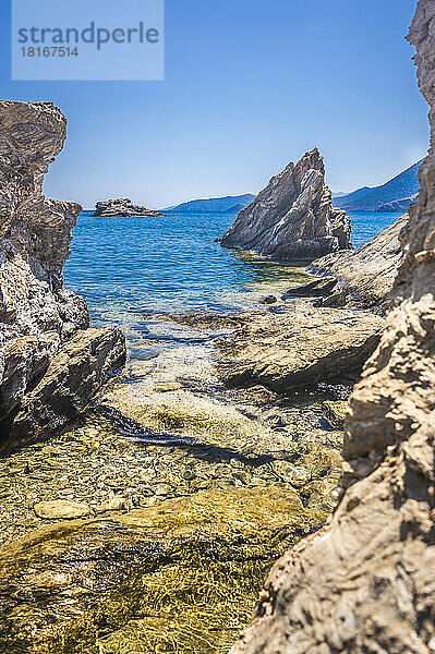 Idyllic shot of rocks in sea on sunny day