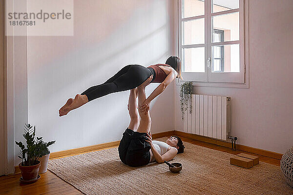 Frauen machen zu Hause Acroyoga