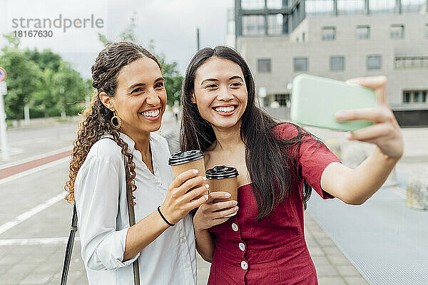 Lächelnde Frau macht Selfie mit Freund auf Smartphone
