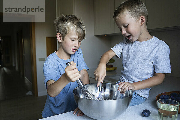 Brüder mischen zu Hause in der Küche Kuchenteig