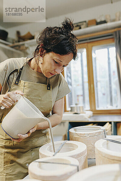 Töpfer gießt in der Werkstatt Ton in Keramik