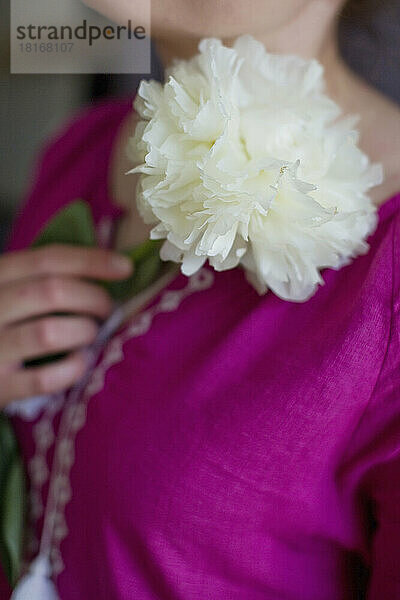 Frau im rosa Vyshyvanka-Kleid mit weißer Pfingstrose