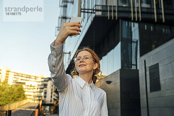 Lächelnde Geschäftsfrau macht Selfie per Smartphone